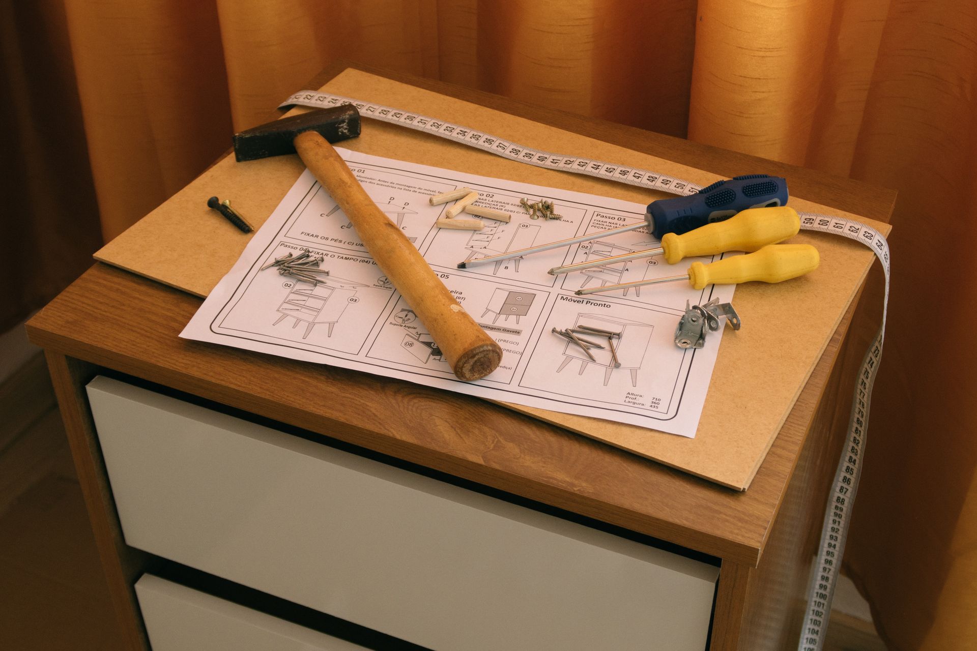 Furniture assembly tools and instructions laid out on a desk
